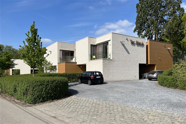 De inrit naar de campus waar de assistentiewoningen Ter Bleuk zich bevinden. De verschillende gebouwen zijn voor de helft opgetrokken uit witte baksteen en de andere helft uit rode baksteen. Op het eerste gebouw is de naam van de assistentiewoningen, in dezelfde kleur als de rode bakstenen, bovenaan de witte gevel geplaatst.