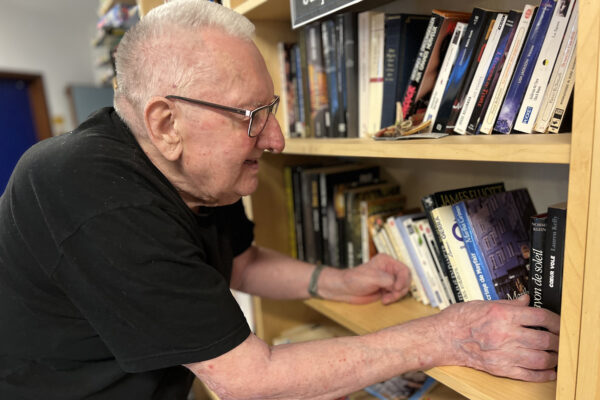 La Passerinette bibliothèque avec un homme devant les livres - Maison de repos - Soumagne